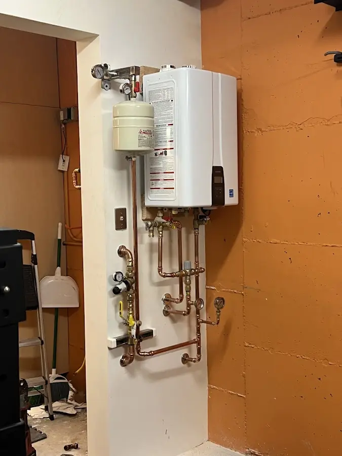 Plumbing technician inspecting water heater connections in Long Prairie